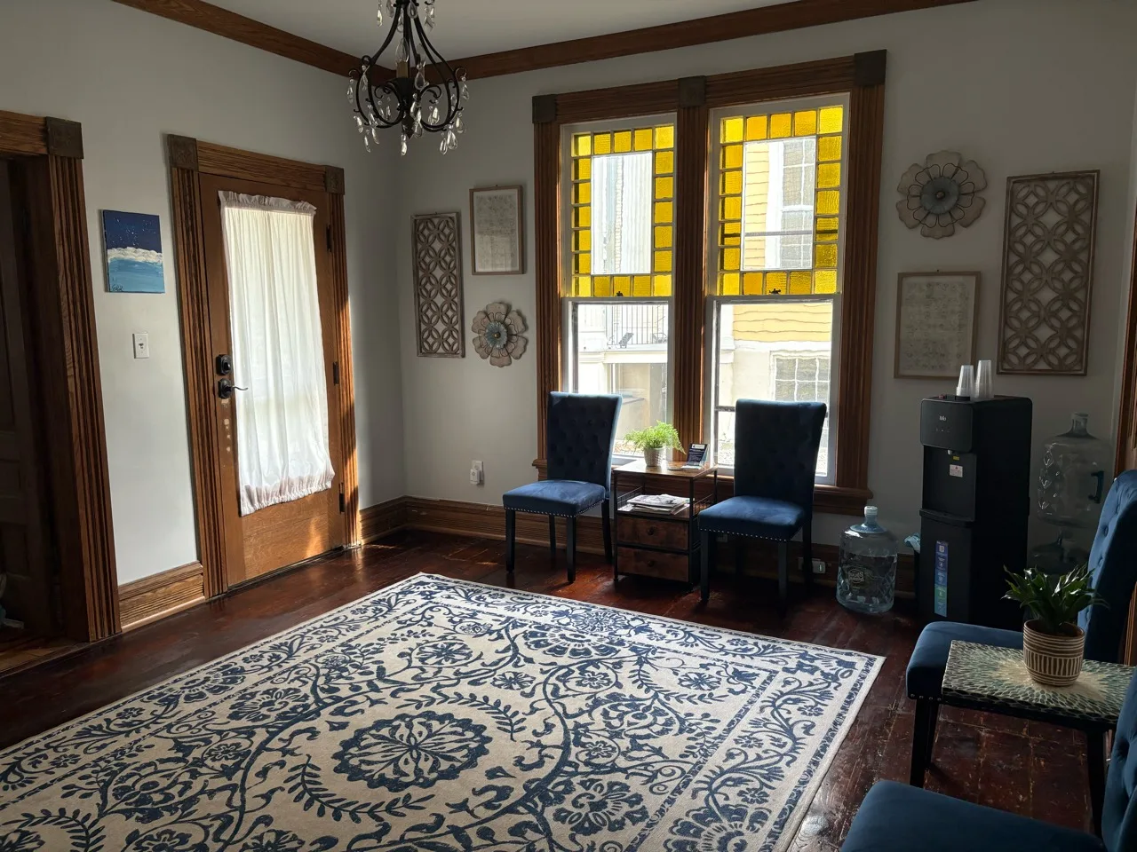 Waiting area with blue chairs beside stained-glass windows